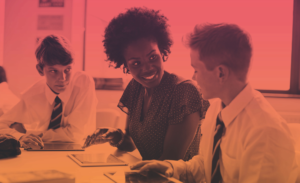 Teacher sitting at a table with two students